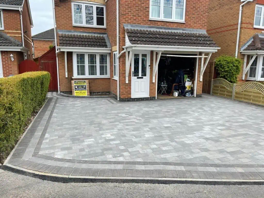 Grey block paving installed with a contrasting perimeter and entrance edge.
