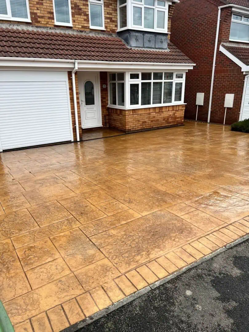 Golden imprinted concrete driveway Golden imprinted concrete driveway with a decorative pattern and contrasting border.