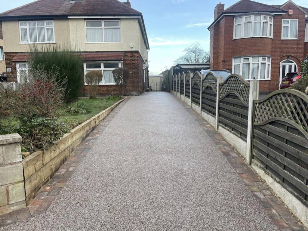 Champagne-pink resin driveway Champagne-pink resin-bound driveway laid across a residential entrance.
