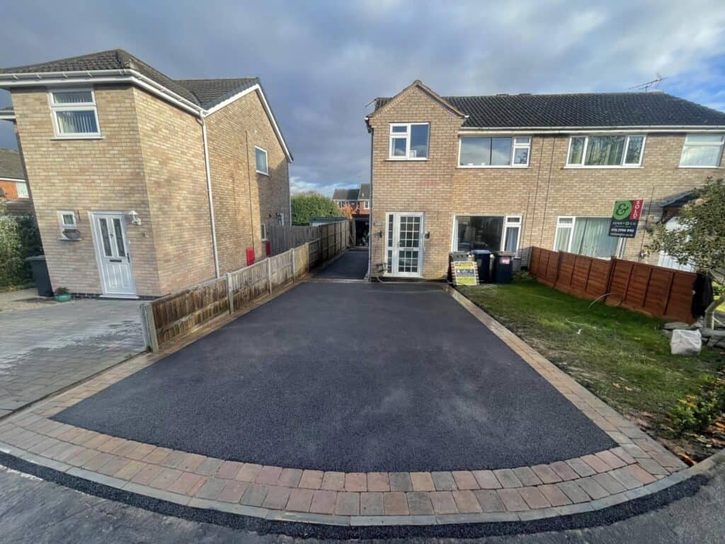 Completed tarmac driveway providing a broad, smooth parking area.