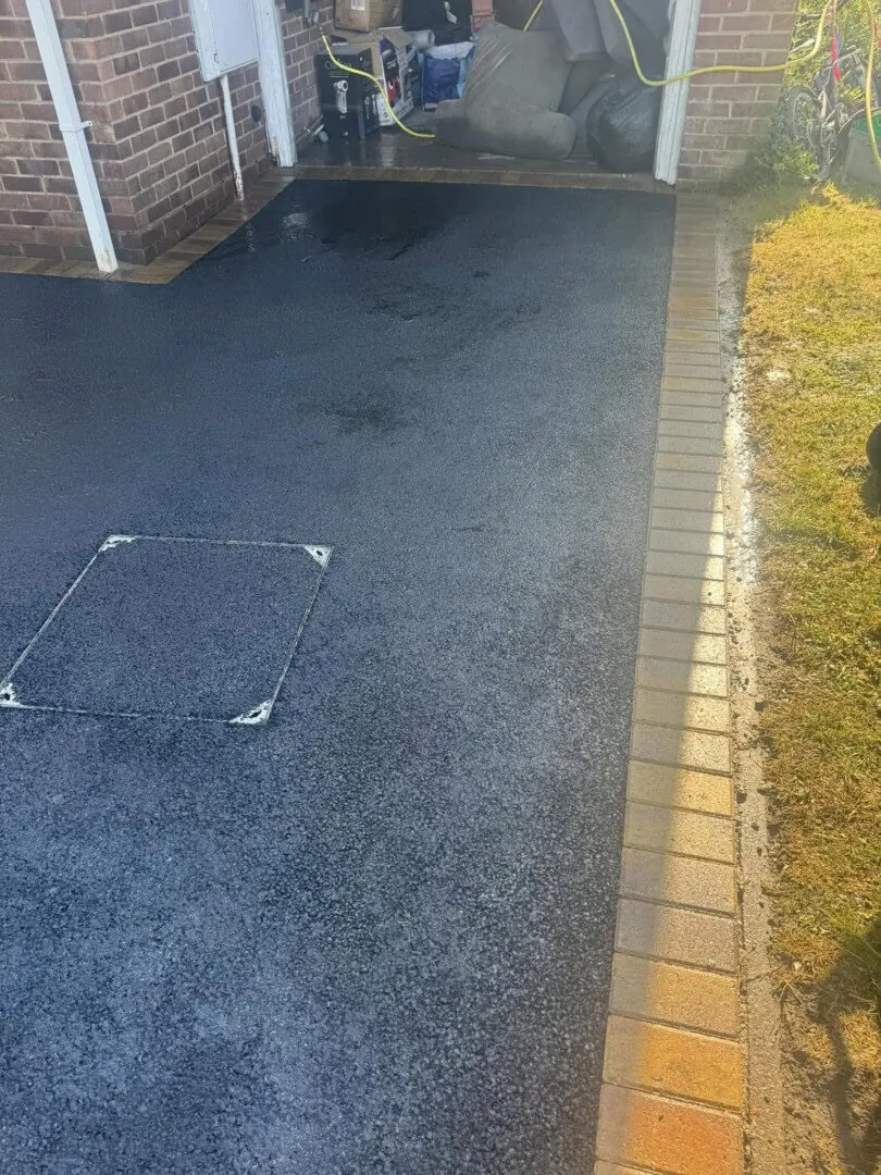 Smooth tarmac driveway with a neat block-paved edge beside a property.